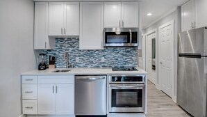 A modern kitchen with white cabinets, stainless steel appliances, and a tiled backsplash. - Awesome Ocean View! Coligny Area! Updated and CLEAN 1 Bedroom! #380 (Hilton Head Island)