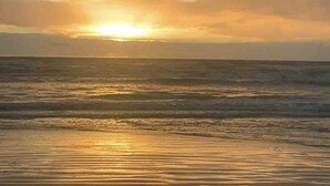 Ein Sonnenuntergang über ruhigem Meer mit klarem Horizont.