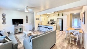 Eine moderne Wohnung mit Wohnzimmer, Küche und Essbereich.
