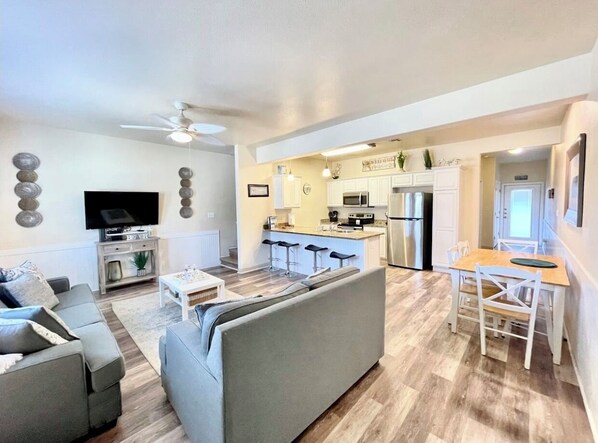 A modern apartment with a living room, kitchen, and dining area.