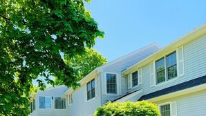 A two-story house with a front porch and a well-maintained lawn. - Jenness Beach Ocean Getaway - Book Now for Summer '26! (Rye)