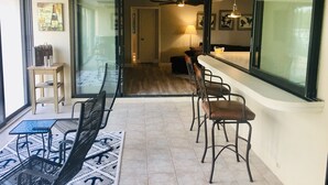 Comedor con separador de vidrio, ventilador de techo y mesa con sillas.