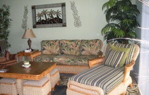 Relax in a cozy seating area with a sofa, armchairs, and a potted plant.