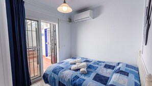 Un dormitorio con cama, ventana y aire acondicionado.