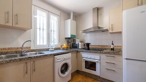 A modern kitchen with a built-in washing machine, oven, and microwave. - Camino de la Huerta Montejaque by Ruralidays (Málaga)