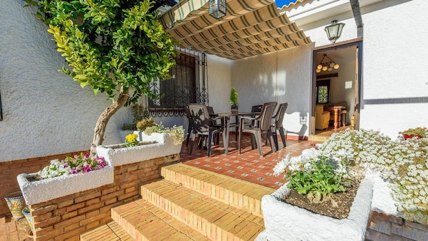 A patio with a table and chairs, a brick staircase, and potted plants. - Recreo San Andrés Ronda by Ruralidays (Málaga)
