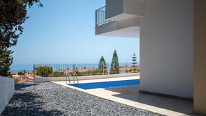 A swimming pool with a view of the sea, surrounded by a white building with a balcony. - Capistrano Garden Nerja by Ruralidays (Málaga)