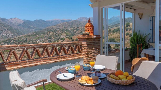 A terrace with a table set for breakfast, overlooking a mountainous landscape. - Villa Manolo Torrox by Ruralidays (Málaga)