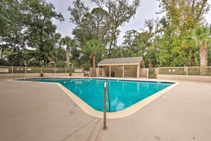 Une piscine dotée d’un poste de surveillance pour les sauveteurs et d’un espace de repos abrité, le tout entouré d’arbres.