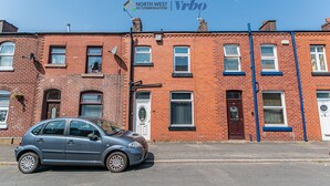 A two-story red brick building with a car parked in front. - Chorley 3BR House | Ideal for Families & Contractors | Long Stays Welcome (Chorley)