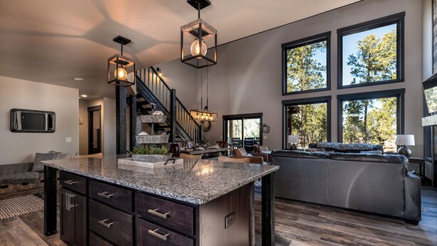 A modern kitchen with a central island, dark wood cabinetry, and pendant lighting.