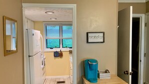 A kitchen with a refrigerator, a coffee maker, and a window with blinds. - Mountain Song - Villa with a View  (Beech Mountain)