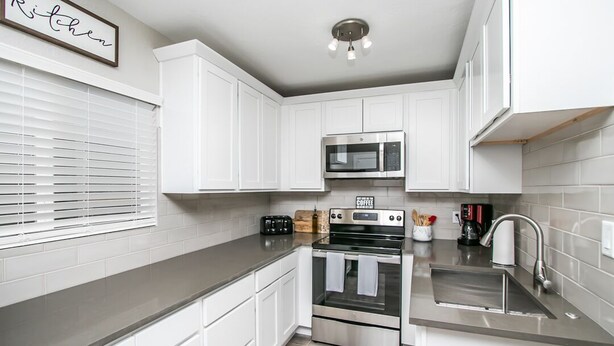 A modern kitchen with white cabinets, a stainless steel microwave, a toaster, and a coffee maker. - 🏜Urban Desert Retreat for the Adventurous Traveler Snow Free-Stay with us! ☀️🐾 (Tempe)