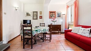 Zona pranzo con tavolo, sedie e televisore.