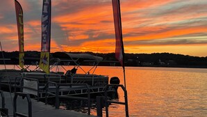 Eine Anlegestelle mit Booten und Flaggen bei Sonnenuntergang.