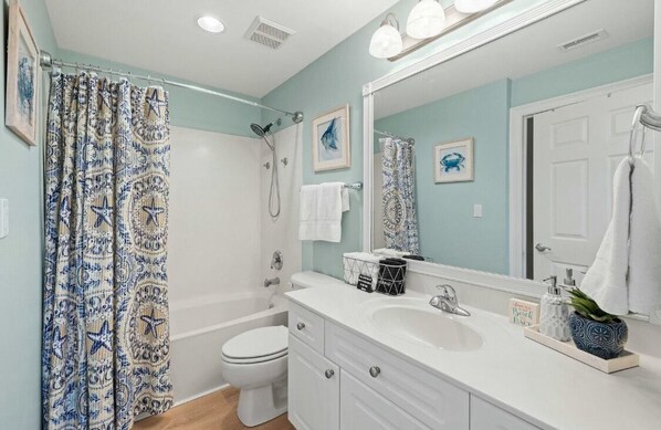 A bathroom with a bathtub, toilet, and sink.