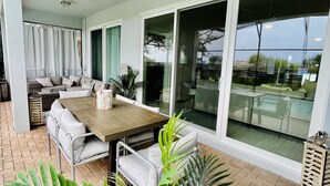 Een terras met een eettafel, stoelen en een plafondventilator.