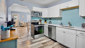 A modern kitchen with white cabinets, a stainless steel oven, a microwave, and a sink. - Family Friendly Home, 4 mins to Beach! - Starfish Cove, B (Holmes Beach)