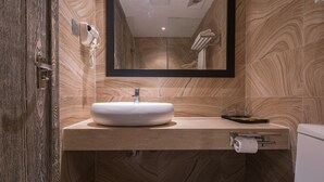 A modern bathroom with a marble vanity, a toilet, and a towel rack. - Art Coffee Hotel (Shenzhen)