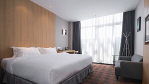 A hotel room with a large bed, a desk, a chair, and a view of the outdoors through sheer curtains. - Art Coffee Hotel (Shenzhen)