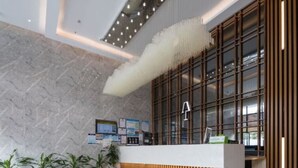 A modern reception area with a marble floor, potted plants, a reception desk, and a large window with vertical blinds. - Art Coffee Hotel (Shenzhen)
