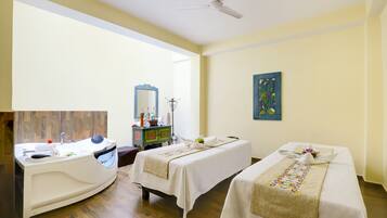 Relax in a spacious room with a large bathtub, vanity, and two comfortable beds.