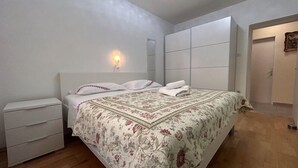 A bedroom with a bed, nightstands, a wall-mounted light, and a door. - Apartment 823/1920 (Istria - Novigrad), 150m from the beach (Novigrad)