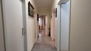 A narrow hallway with white walls and a tiled floor. There are doors on both sides, and a framed picture hangs on the left wall. - Apartment 823/1920 (Istria - Novigrad), 150m from the beach (Novigrad)