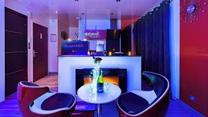 Un moderno vestíbulo de hotel con una recepción, una chimenea y dos sillones de descanso.