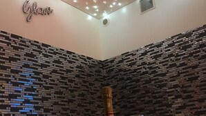 Una cocina moderna con salpicadero de azulejos blanco y negro, encimera de acero inoxidable y una botella de champán con dos copas sobre la encimera.
