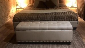 A bedroom with a large bed, a matching bench, and two wall-mounted lamps. - CENTRAL APARTMENT (BARI)