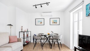 Uma sala de estar moderna com sofá, mesa de centro e aparador para TV.