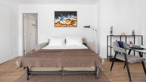 Um quarto com uma cama, uma escrivaninha e uma cadeira.