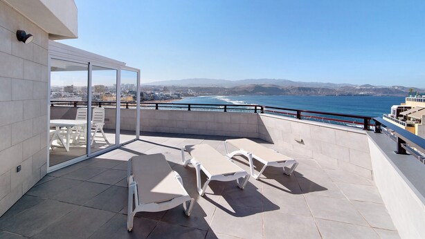 Una terrazza sul tetto con vista aperta sull'oceano e sulla città.