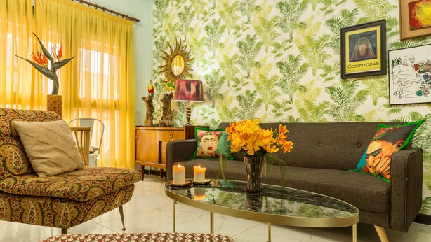 A living room with a patterned sofa, a coffee table, and a decorative plant.