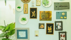 A wall with various framed artworks, a globe, and a map.
