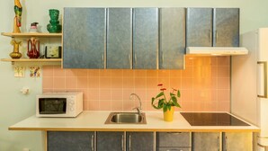 A kitchen with a microwave, sink, and cabinets.