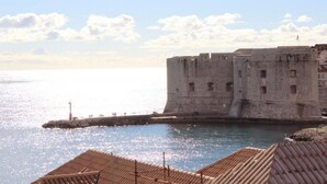 A historic stone fortress by the sea with a clear sky. - Room Lazareti (Dubrovnik)