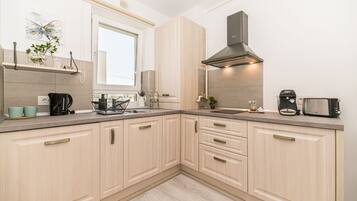 Deluxe Studio Suite | Private kitchen | Fridge, microwave, oven, coffee/tea maker