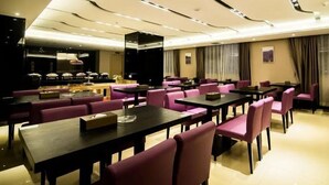 A hotel dining area with multiple tables and chairs, a buffet setup, and a modern ceiling design. - Lavande Hotel (Jiangmen)