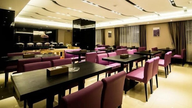 A hotel dining area with multiple tables and chairs, a buffet setup, and a modern ceiling design. - Lavande Hotel (Jiangmen)