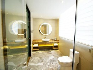 A modern bathroom with a glass shower enclosure, a marble floor, a white toilet, and a vanity with a mirror. - Lavande Hotel (Jiangmen)
