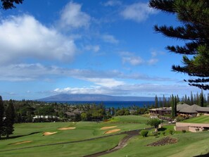 A golf course with a view of the ocean and a mountain in the distance. - Kapalua Ridge Villa 1214 Gold Ocean View (Lahaina)