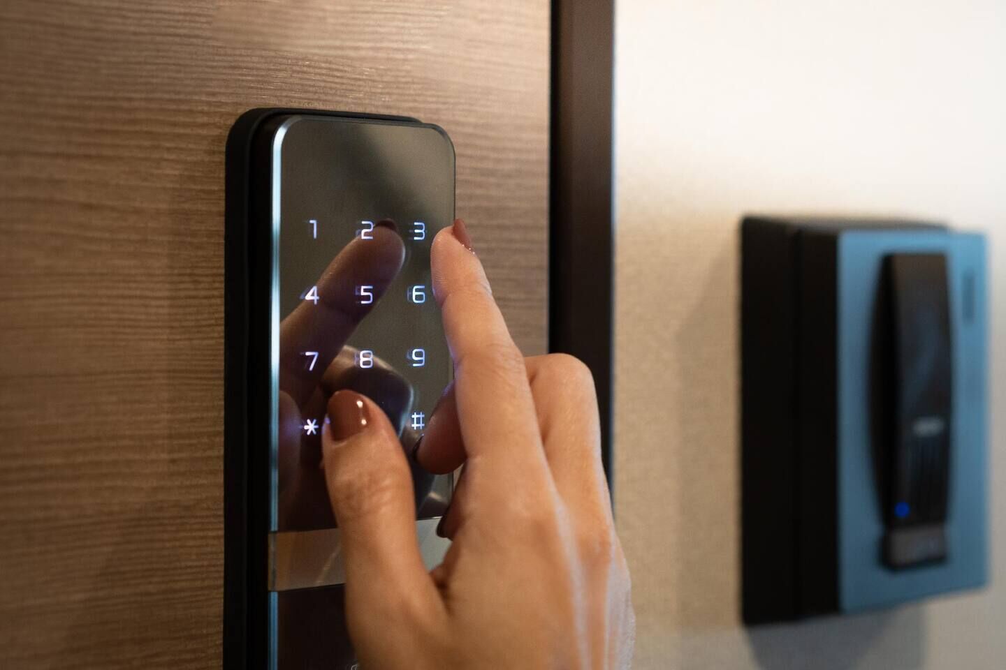 Une main utilisant un clavier numérique sur un système de verrouillage de porte.