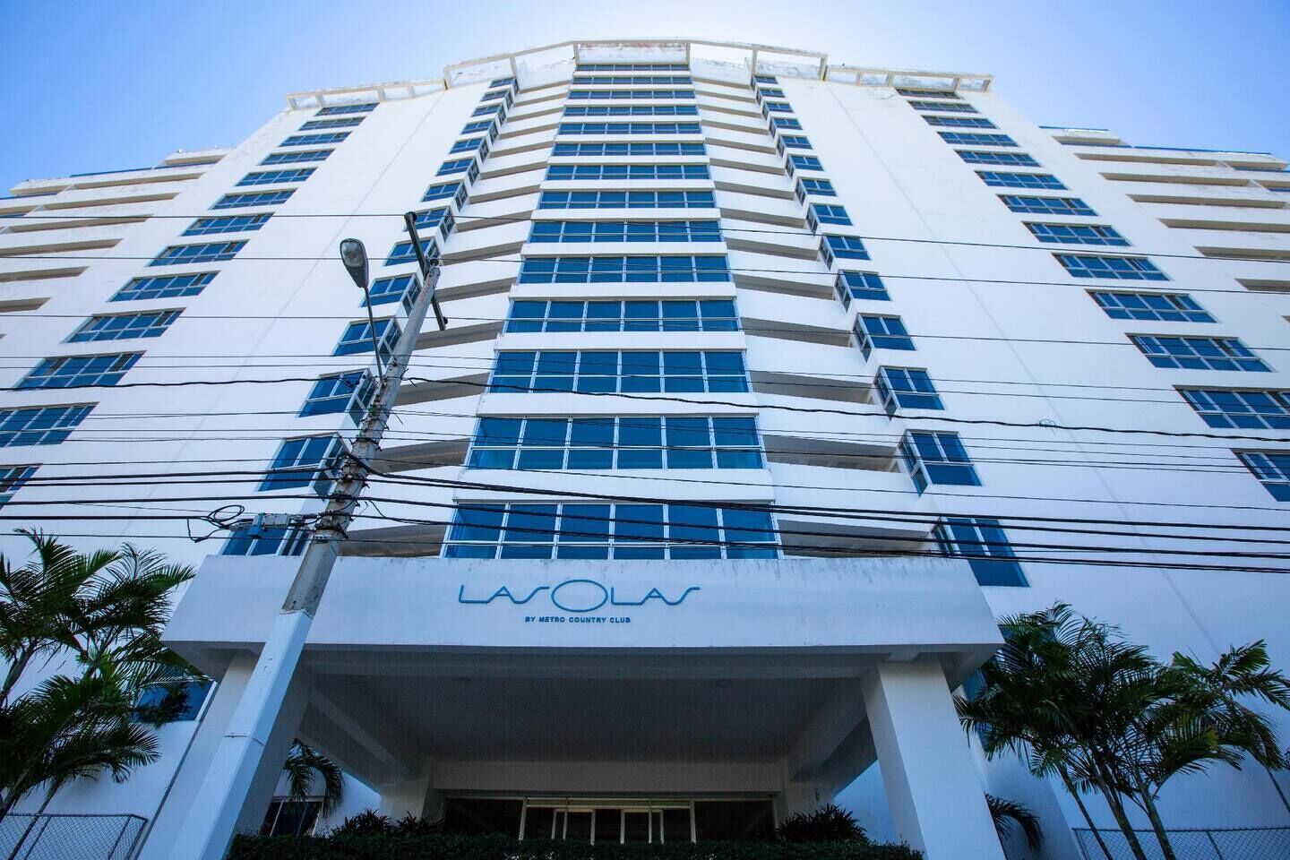 A high-rise hotel with a modern design, featuring a prominent "Las Vegas" sign at the entrance.