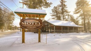 Une enseigne de motel avec un toit enneigé et une structure en bois.