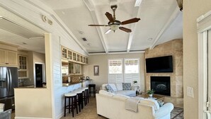 A spacious living area with a large sofa, a dining area with bar stools, a kitchen with a central island, and a fireplace. - Oceanfront 4 Bedroom 4.5 Bathroom House on A Street St Augustine (St. Augustine)