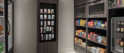 A self-service kiosk with various packaged goods and a refrigerated section with beverages.
