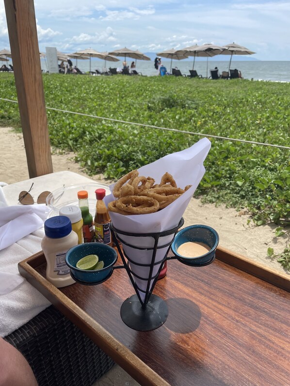 A tray with a basket of fried calamari, condiments, and a lime wedge on a beach setting. - Reduced Rate for 2 Bedroom Condo w Ocean View at Luxury Resort in Nuevo Nayarit (Nuevo Vallarta)