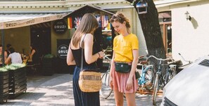 Dos personas están de pie frente a un café, con bicicletas estacionadas cerca.